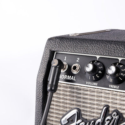 Fender guitar amplifier with a cable plugged in on a white background