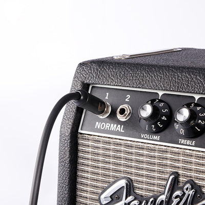Fender amplifier with a cable plugged into the input jack on a white background