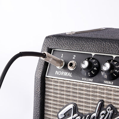 Fender guitar amplifier with a cable plugged into the input jack on a white background