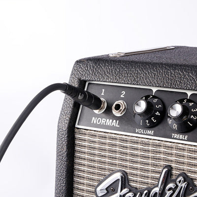 Fender amplifier with a cable plugged in on a white background
