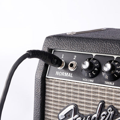Fender guitar amplifier with a cable plugged in on a white background