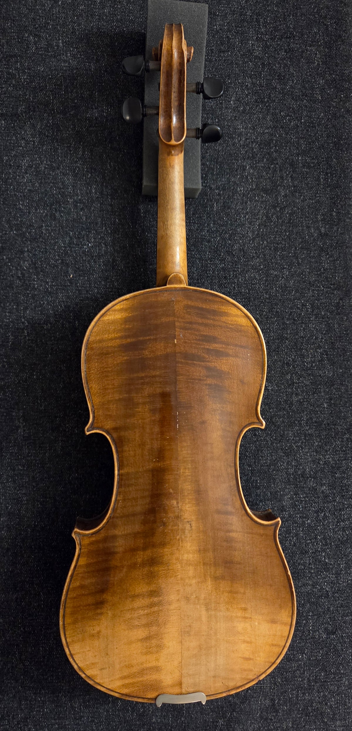 Back of antique violin on a grey background