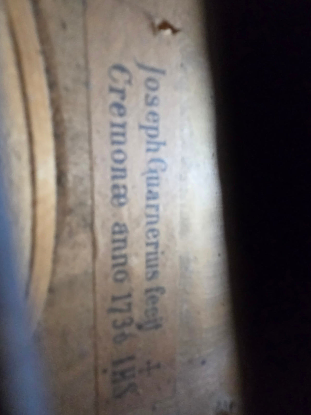 Joseph Guarnerius fecit Cremonae 1736 label inside of a violin seen through f-hole.