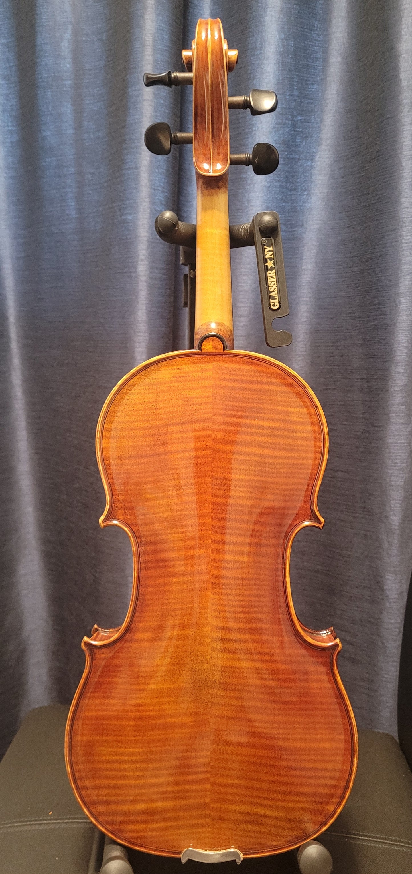 Violin on a stand against a gray curtain background